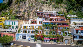 Un paese costiero con edifici colorati, una strada con attraversamento pedonale e una scogliera.