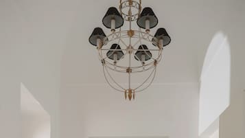 Una cocina moderna con armarios blancos, suelo de baldosas hexagonales y una lámpara colgante original.