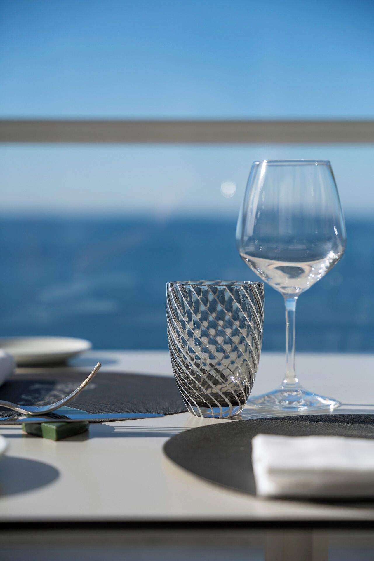 A table set for dining with a clear view of the ocean in the background.