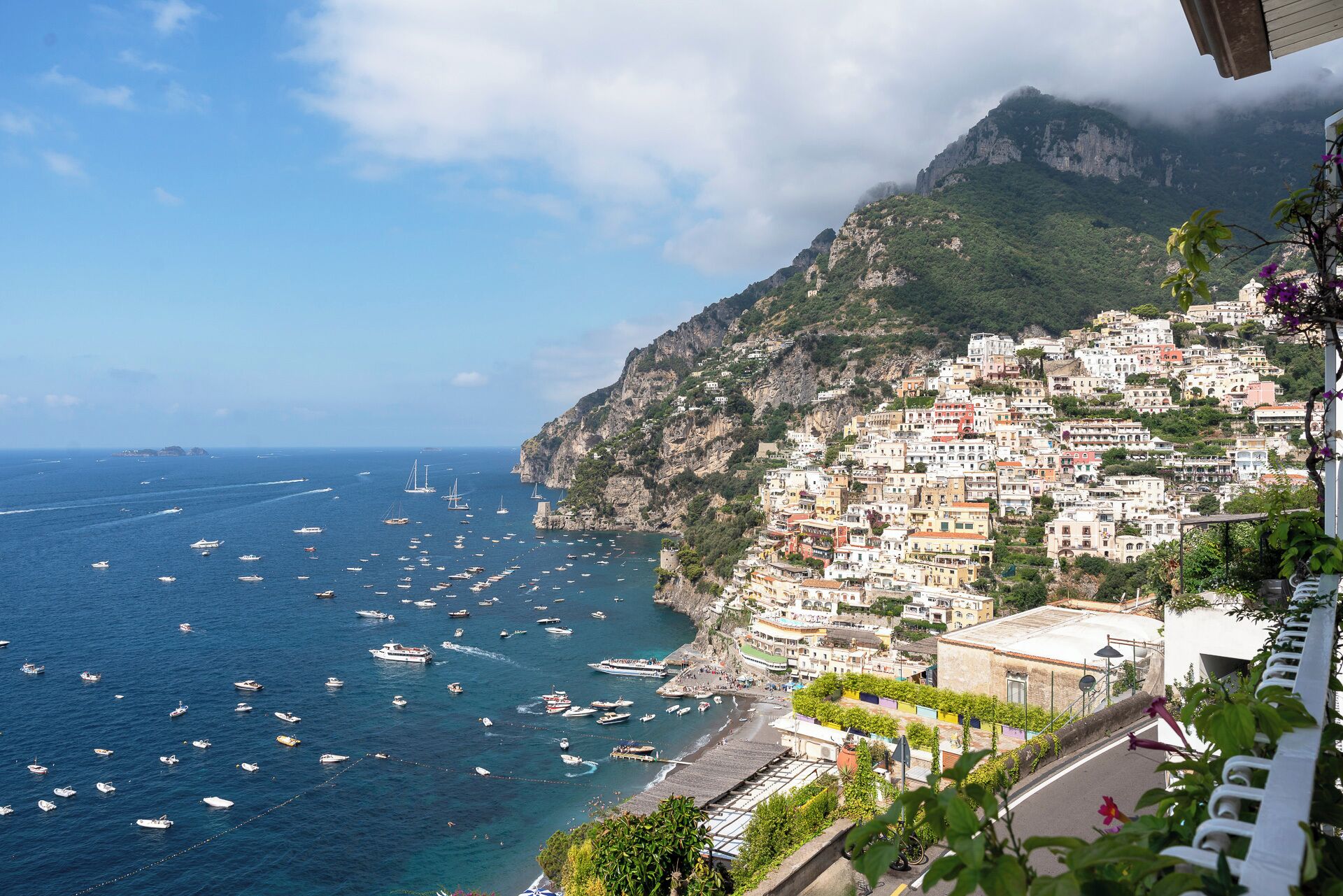 A coastal town with buildings stacked on steep cliffs overlooking the sea.