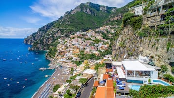 Uma vila costeira com edifícios numa encosta com vista para o mar.