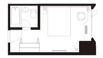 A floor plan of a hotel room with a bathroom, a bed, a desk, and a chair.