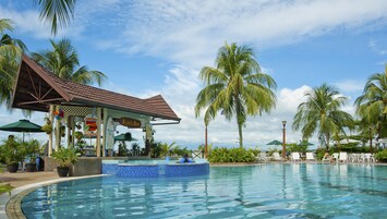 Una piscina al aire libre, sombrillas
