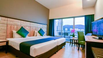 A hotel room with a large bed, a desk, and a view of the city.