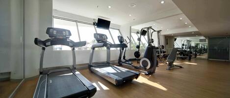 A gym with treadmills, a stationary bike, and weight machines.