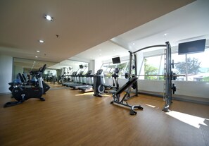 A gym with various exercise machines, large windows, and a wooden floor. - Flamingo By The Beach Penang (George Town)