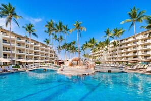 A hotel pool with palm trees, lounge chairs, and a bridge. - Villa del Palmar Beach Resort and Spa, Puerto Vallarta (Puerto Vallarta)