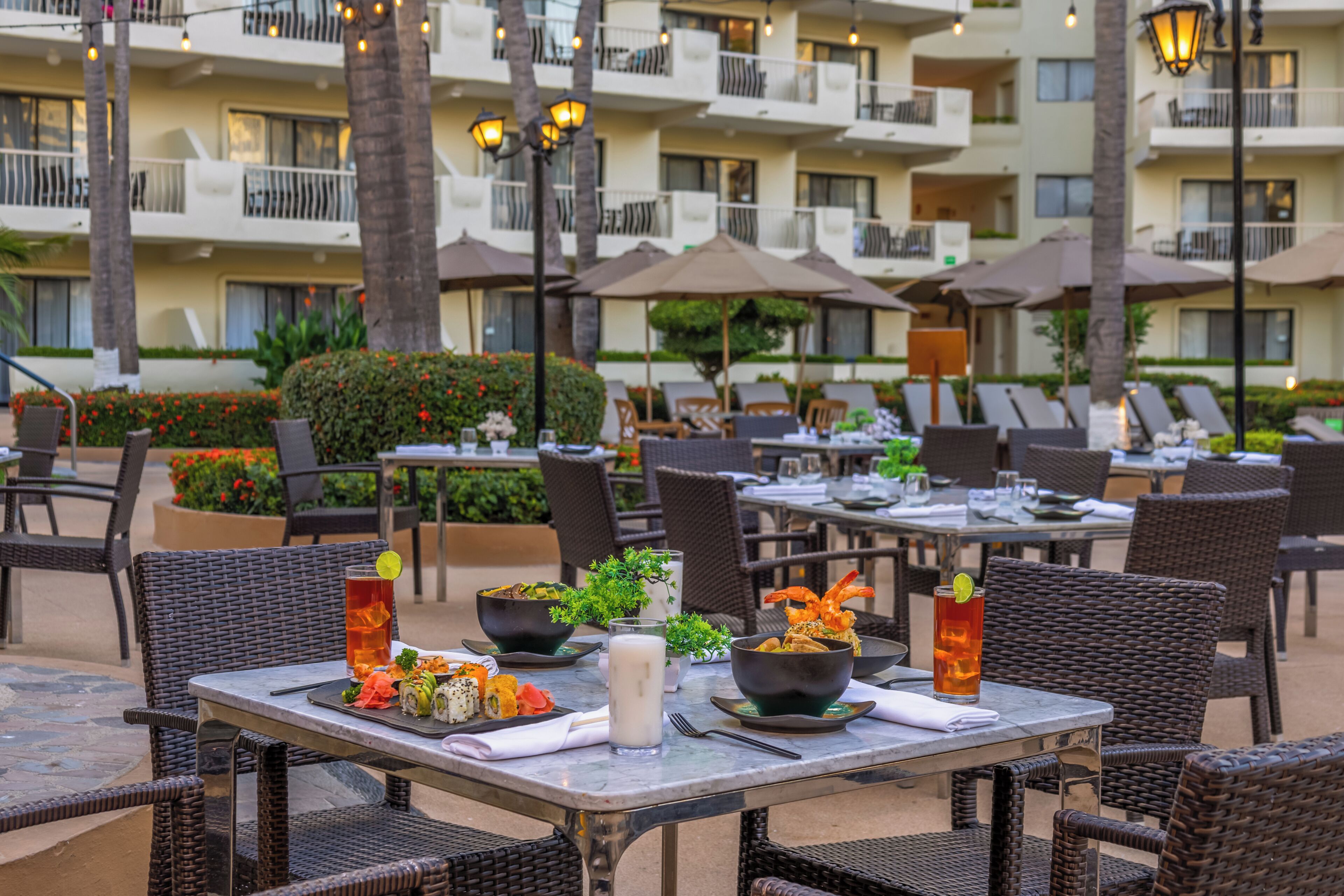 An outdoor dining area with tables, chairs, and umbrellas.