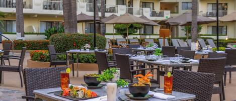 An outdoor dining area with tables, chairs, and umbrellas.