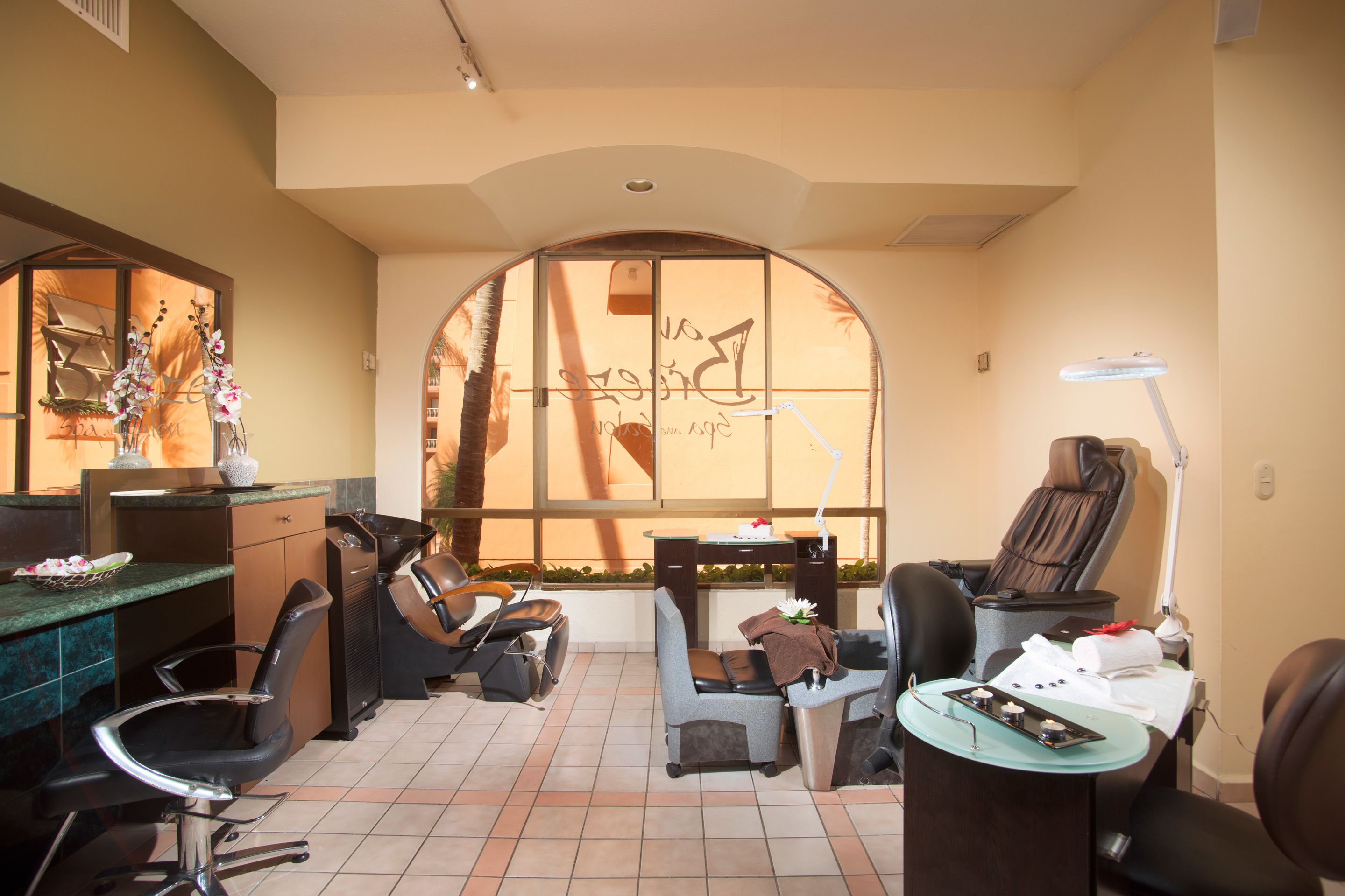 Un salon doté de plusieurs fauteuils, d’un comptoir d’accueil et d’une grande fenêtre en arc de cercle.
