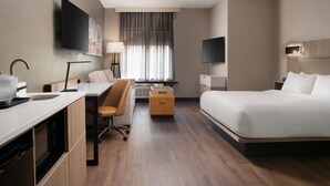 A hotel room with a bed, desk, chair, and a TV mounted on the wall. - Springhill Suites Marriott Little Rock West (Little Rock)