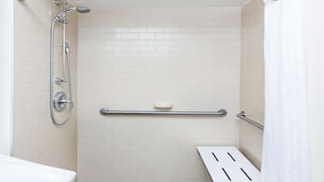 A bathroom with a shower, a toilet, and a grab bar.