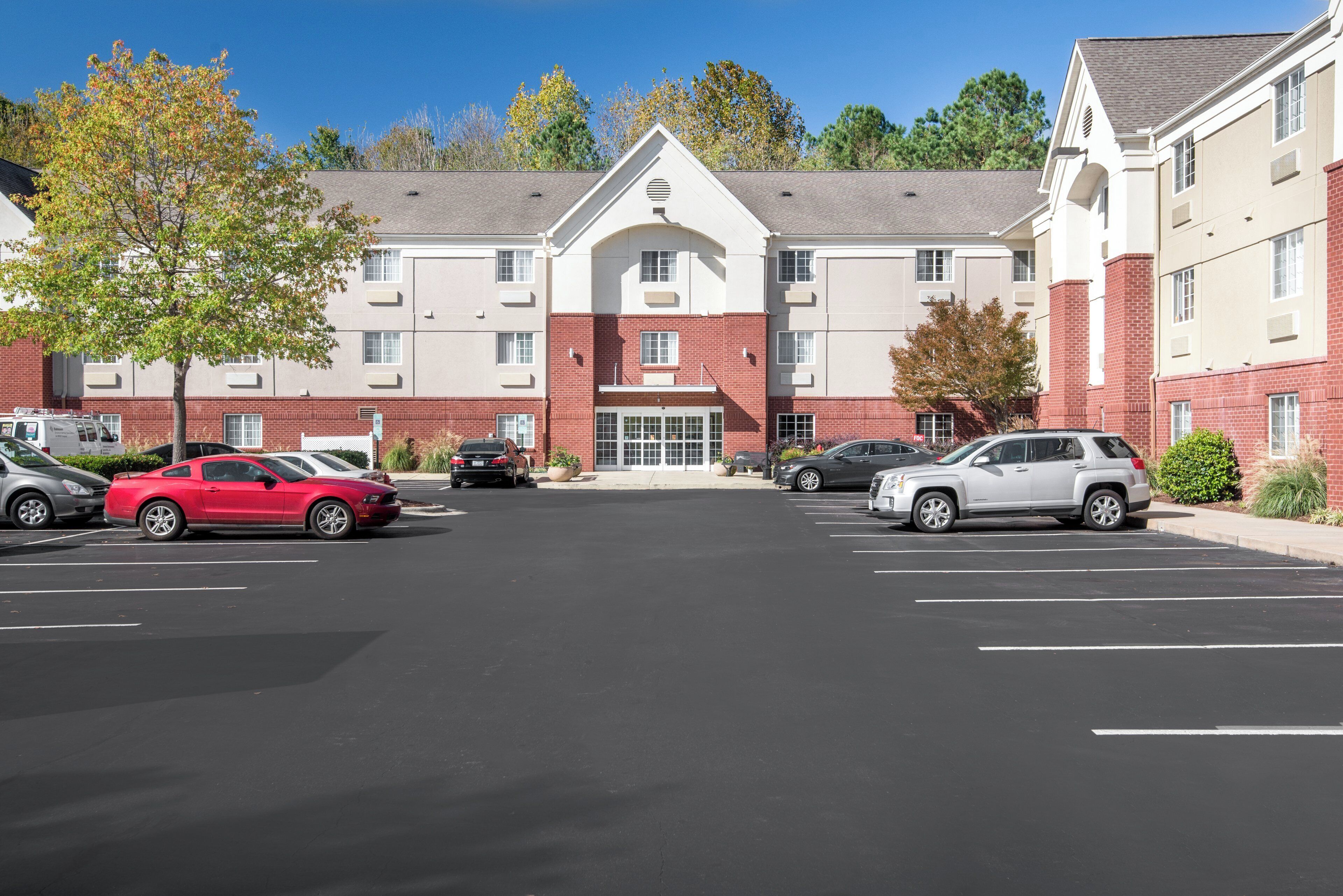 A multi-story hotel with a parking lot in front.