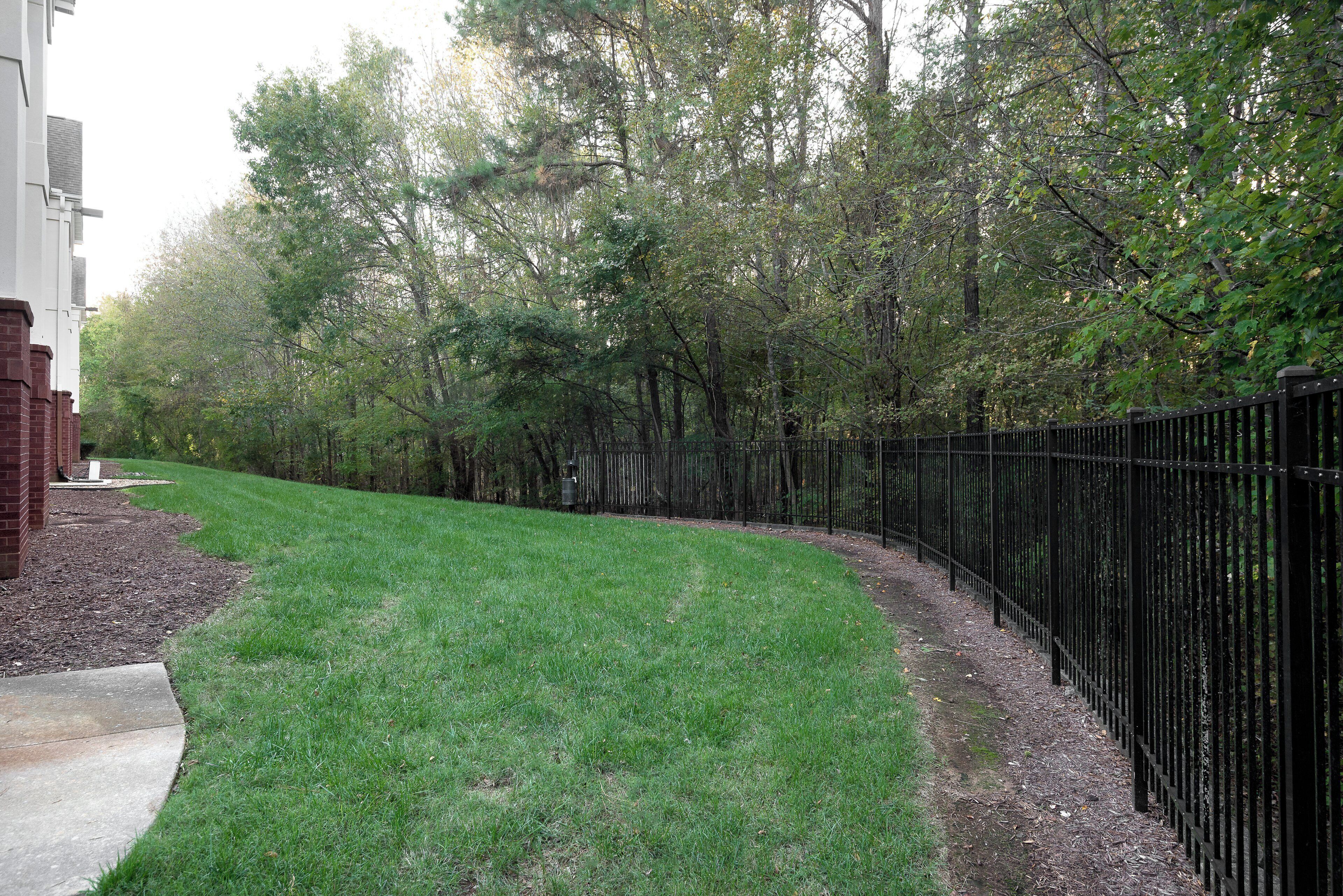 A grassy pathway leading to a building with a brick facade.
