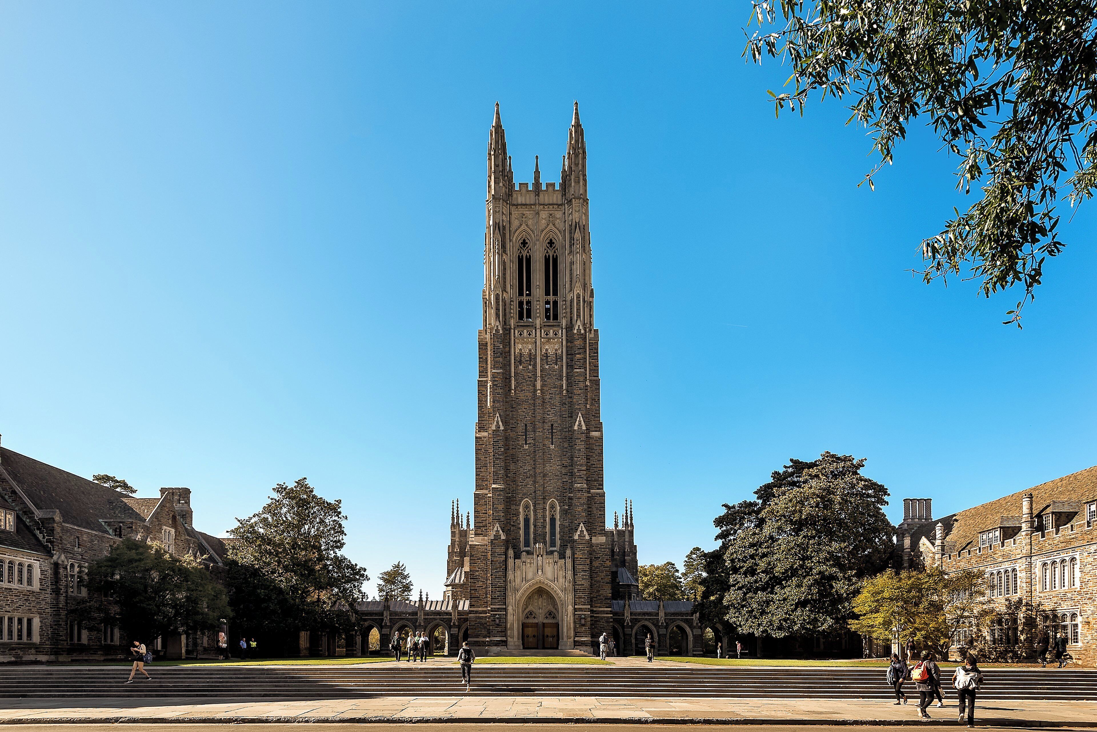 A historic church with a tall tower, surrounded by a campus with steps leading to the entrance.