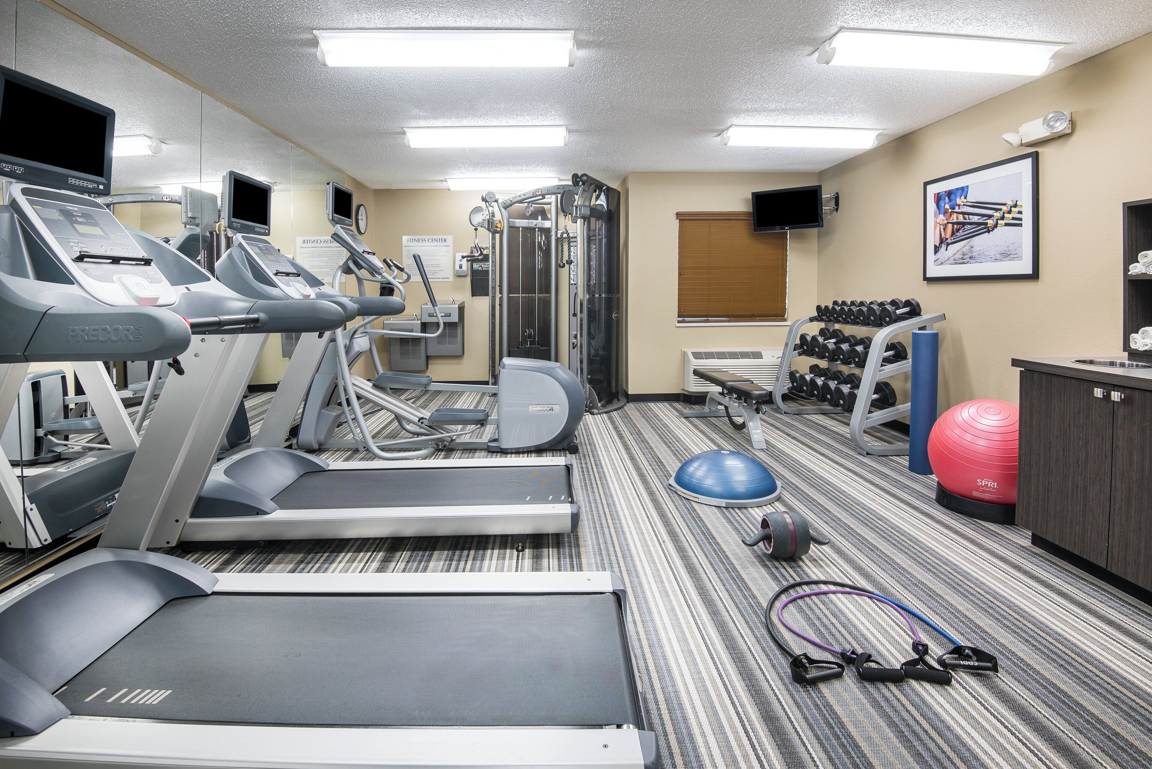 A fitness center with treadmills, weight machines, and exercise balls.
