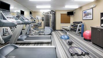 A fitness center with treadmills, weight machines, and exercise balls.