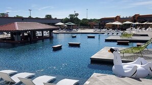 Une piscine dotée de chaises longues et de bouées en forme de cygne.