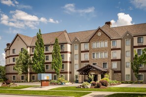 A multi-story hotel with a central entrance, surrounded by well-maintained lawns and trees. - Sonesta ES Suites Toronto Markham (Markham)