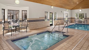 A swimming pool with a tiled deck, chairs, and a view of the outdoors. - Staybridge Suites MPLS-Maple Grove/Arbor Lakes by IHG (Maple Grove)