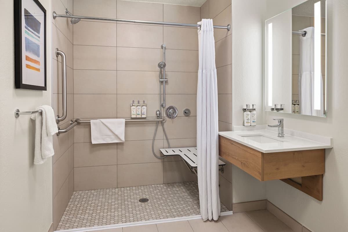 A modern bathroom with a shower, a toilet, and a sink.