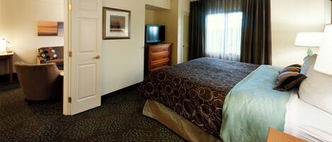 A hotel room with a bed, a television, a desk, and a chair.