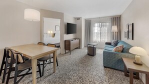 A hotel room with a dining area, a sofa, a TV, and a lamp. - Sonesta ES Suites Austin The Domain Area (Austin)