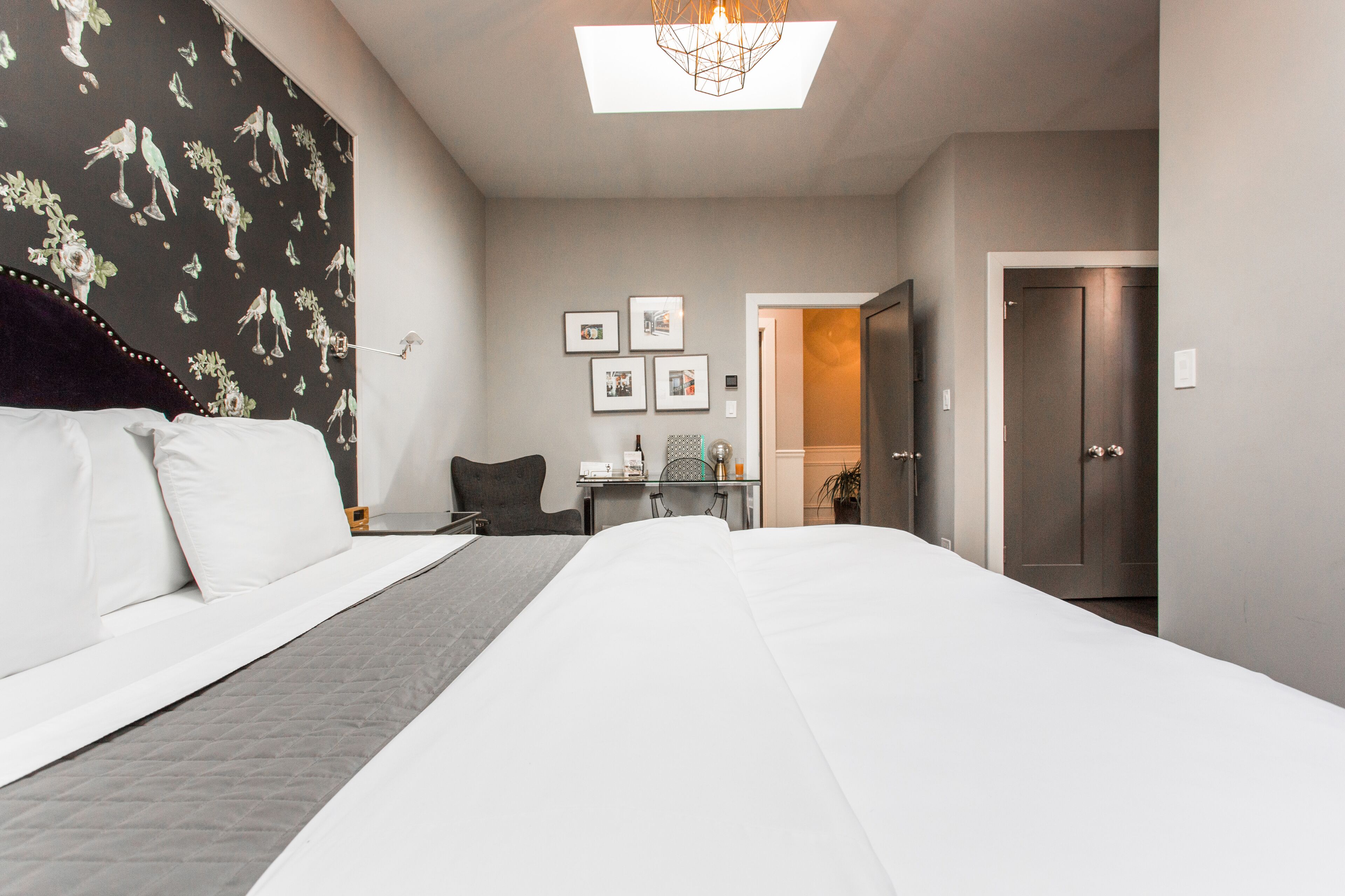 Una habitación de hotel con una cama grande, un escritorio, una silla y una puerta.