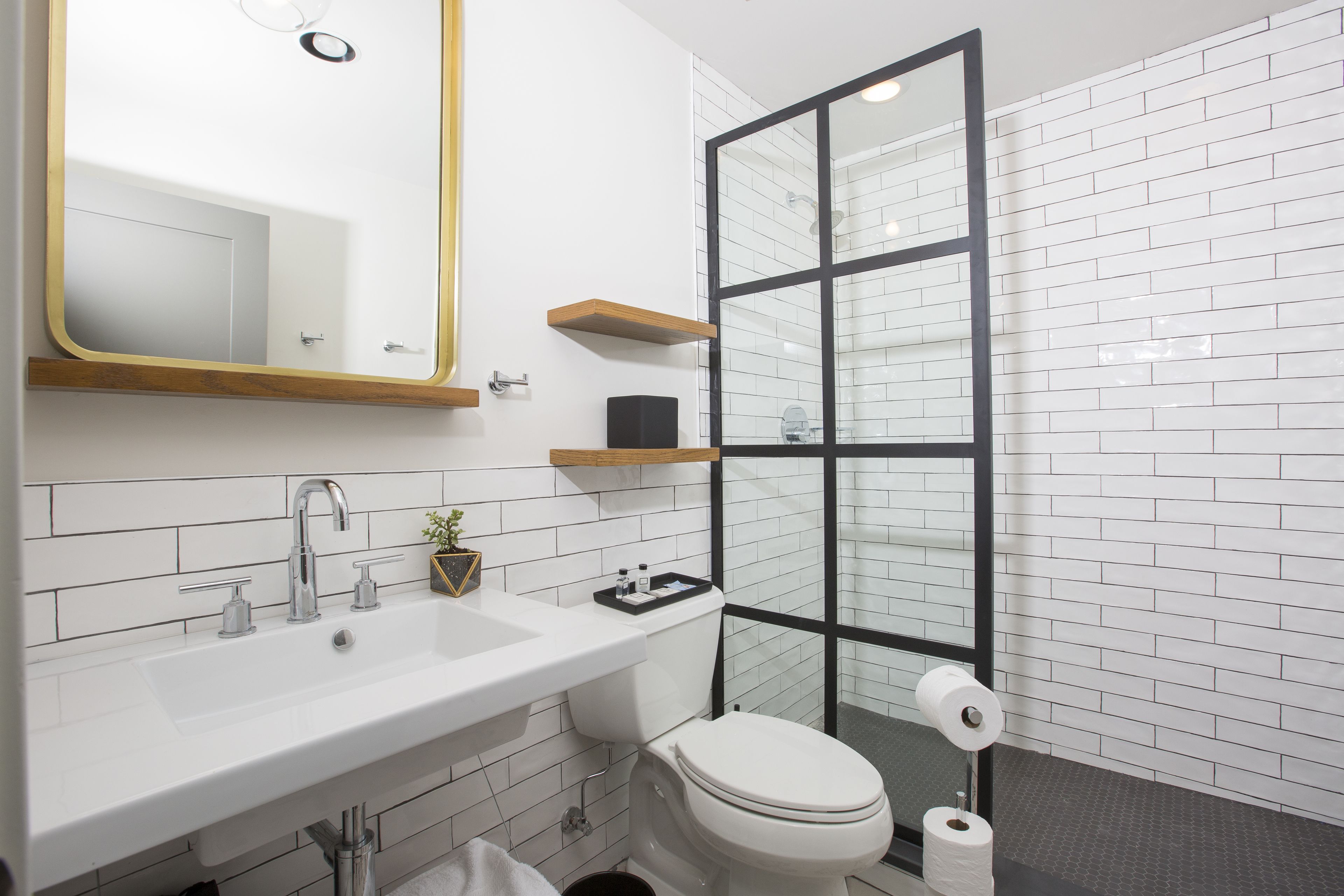 Un baño moderno con un lavabo blanco, un inodoro y una cabina de ducha de vidrio.