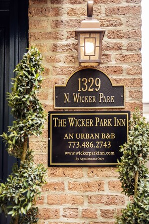 A brick building with a sign for The Wicker Park Inn, including a phone number and website. - Wicker Park Inn (Chicago)