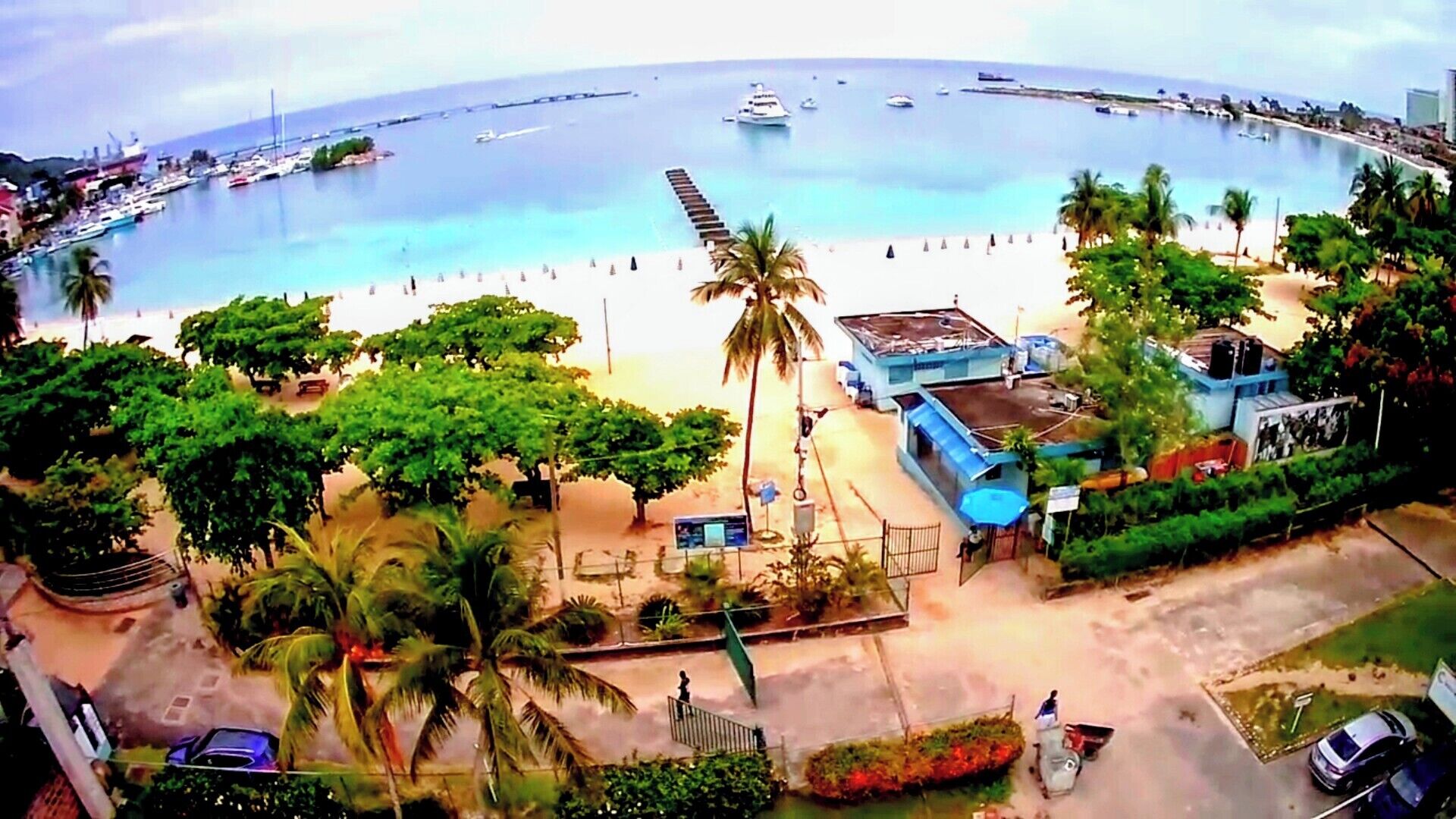 A coastal area with a beach, boats, and a pier.