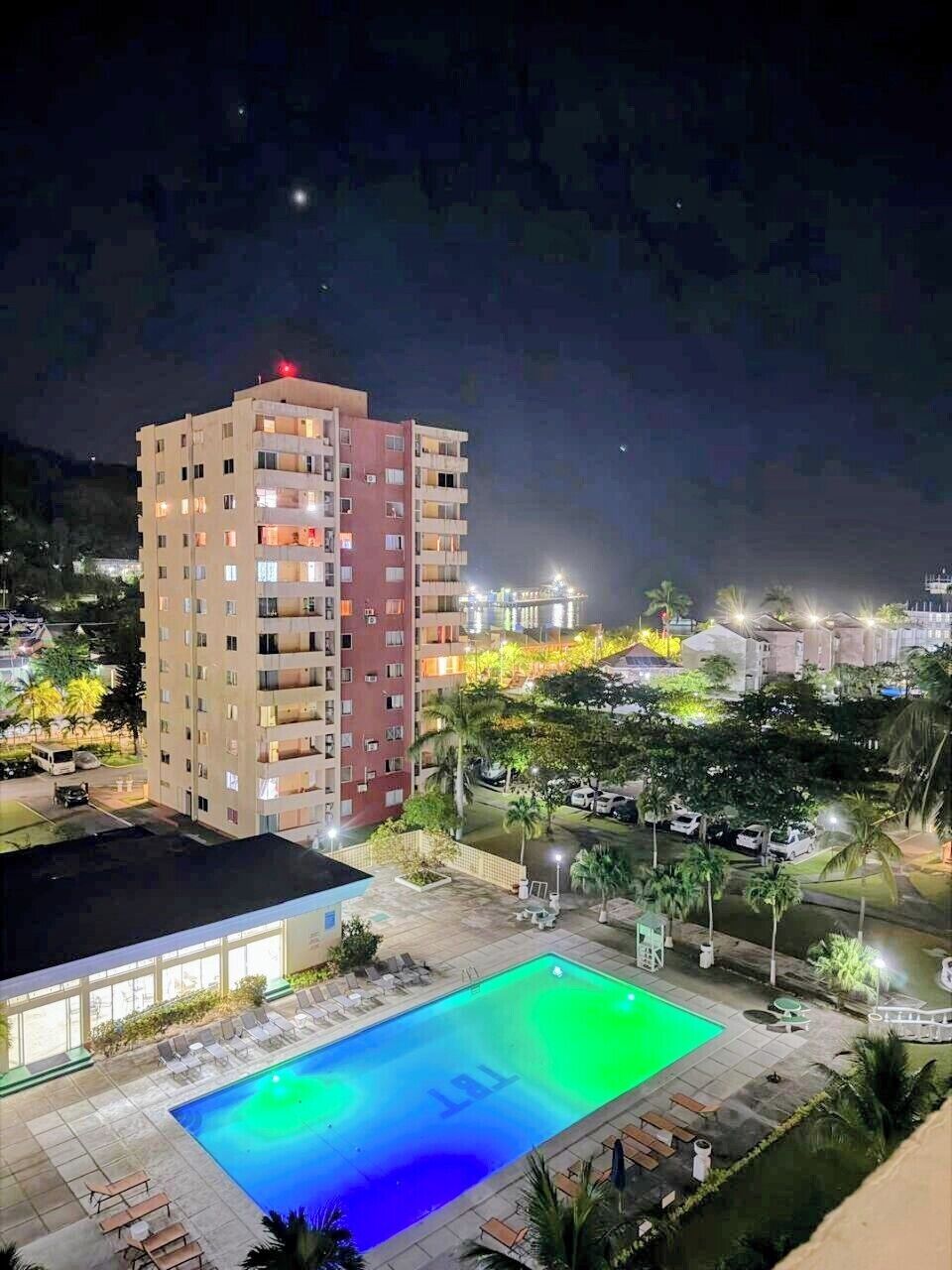 Een hotel met meerdere verdiepingen, een zwembad, terras en uitzicht op de omgeving.