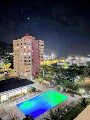 A multi-story hotel with a swimming pool, outdoor seating, and a view of the surrounding area. - Beach Side Condos at Turtle Beach Towers (Ocho Rios)