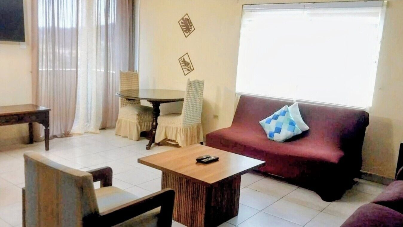A living room with a sofa, a table, and a chair.