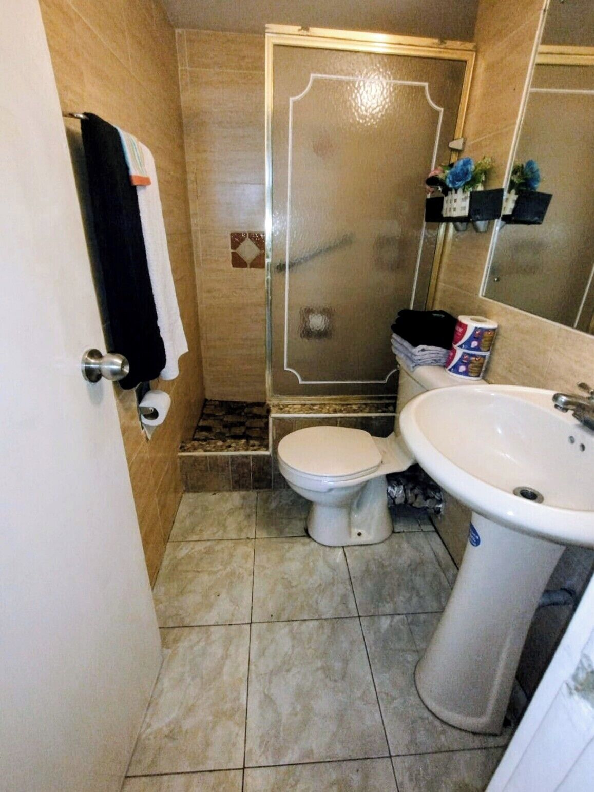 A bathroom with a toilet, sink, and shower.