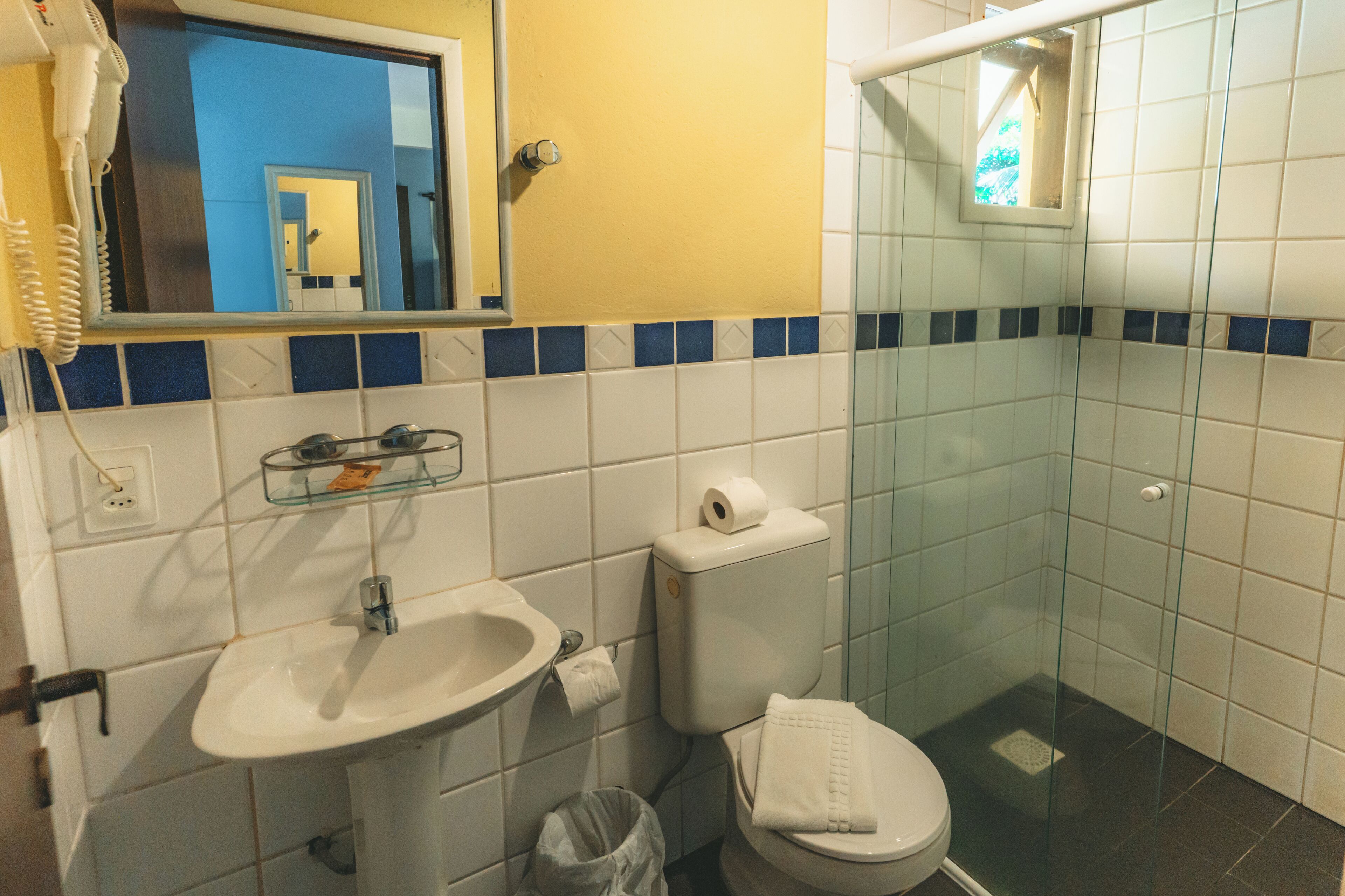 Een badkamer met een wastafel, toilet en glazen douchecabine.