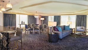 Ein Hotelzimmer mit Essbereich, einer Sofagarnitur und einem Kronleuchter.