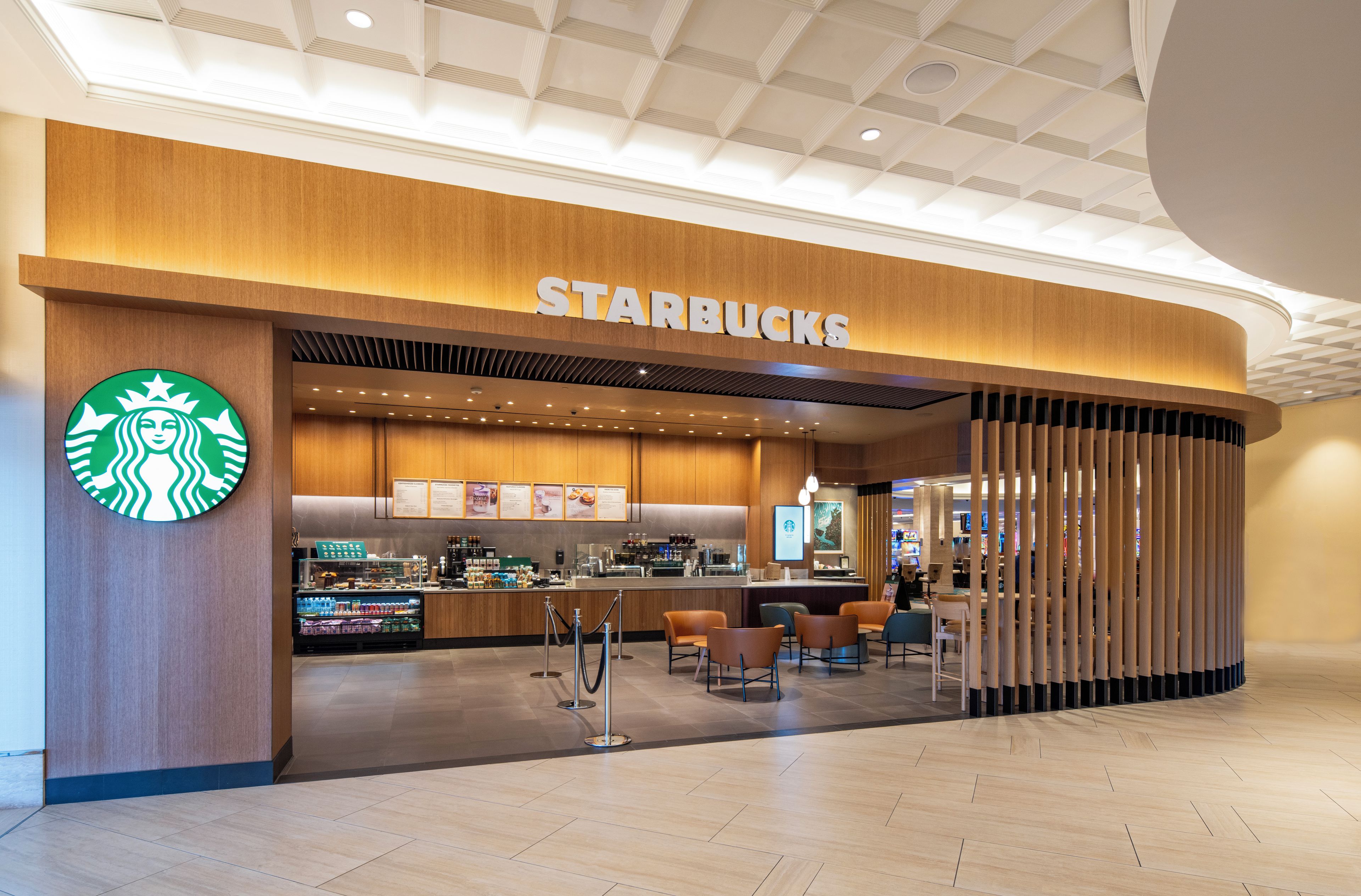 Starbucks-myymälä, jossa on puinen julkisivu, näkyvä kahletiski ja asiakaspaikkoja.