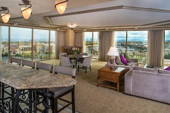 A gym with various exercise equipment, a television mounted on the wall, and large windows offering a view of the outdoors. at Suncoast Hotel and Casino