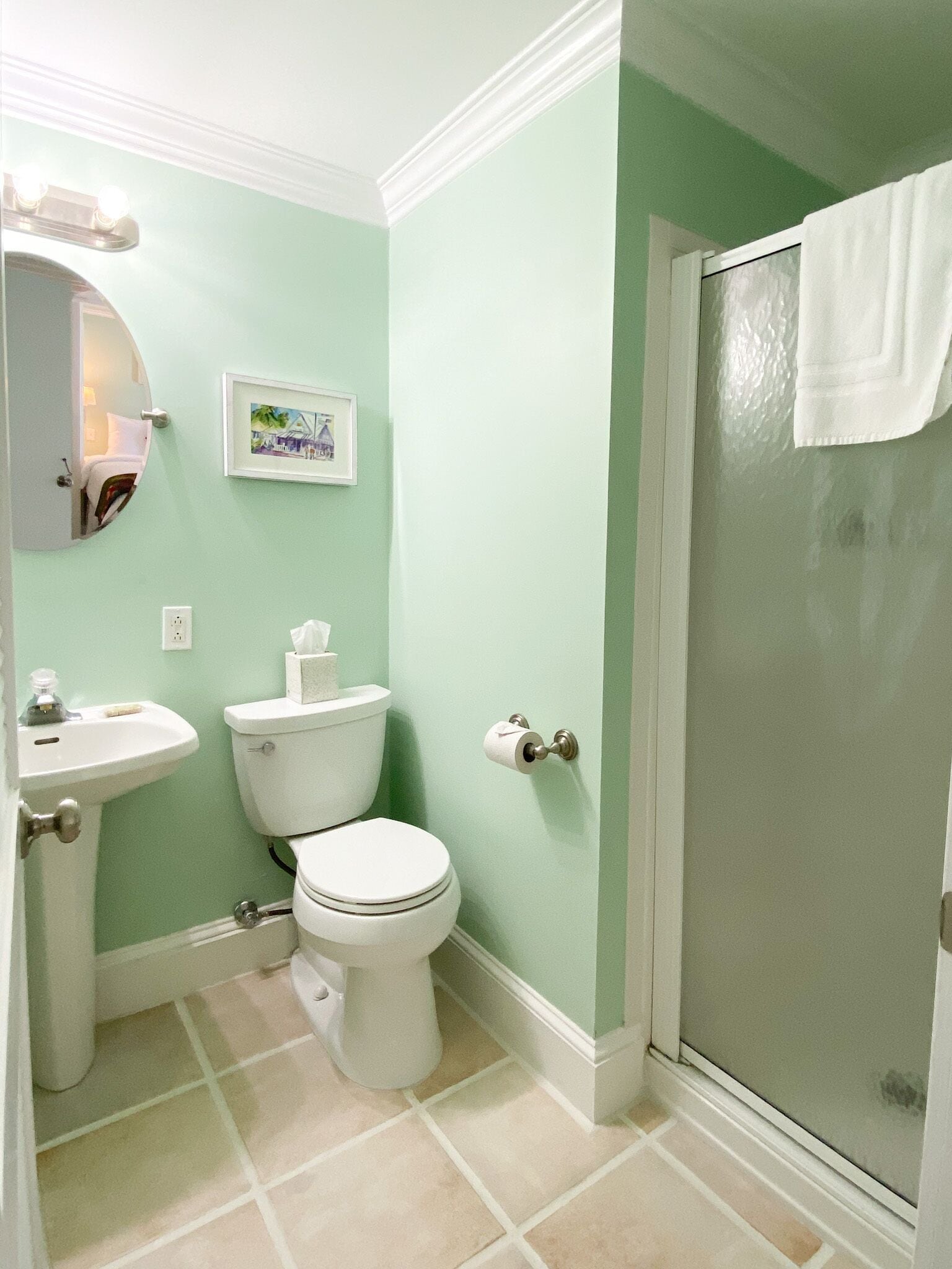 A bathroom with a toilet, sink, and shower.