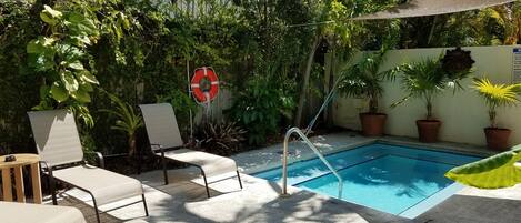 A pool area with lounge chairs and a lifebuoy.