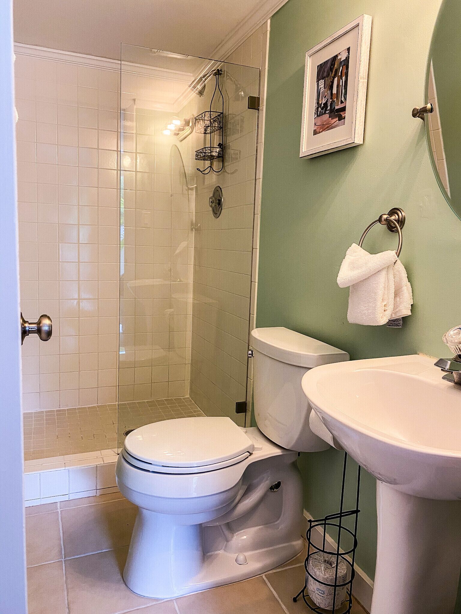 A bathroom with a toilet, sink, and shower.