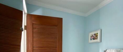 Un baño con puerta de madera, inodoro blanco y bañera.