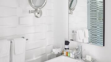 A modern bathroom with a white sink, two wall-mounted mirrors, and a large mirror above the sink.