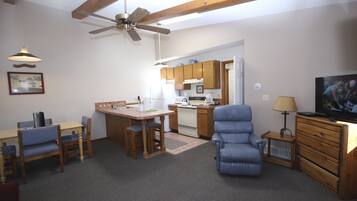 A compact living space with a dining area, kitchen, and seating area.