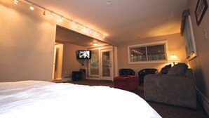 A hotel room with a bed, a TV, a sofa, and a window.