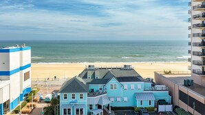 Un hotel costero con vista a la playa, que presenta una construcción de dos pisos con balcones y techo plano.