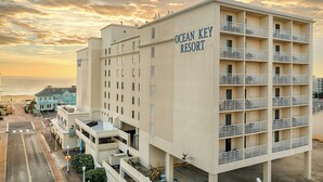 Un hotel de varios pisos llamado Ocean Key Resort, con un letrero visible, balcones y vistas al océano.