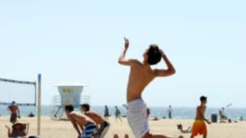 Guests can enjoy a game of beach volleyball in a lively public beach setting.