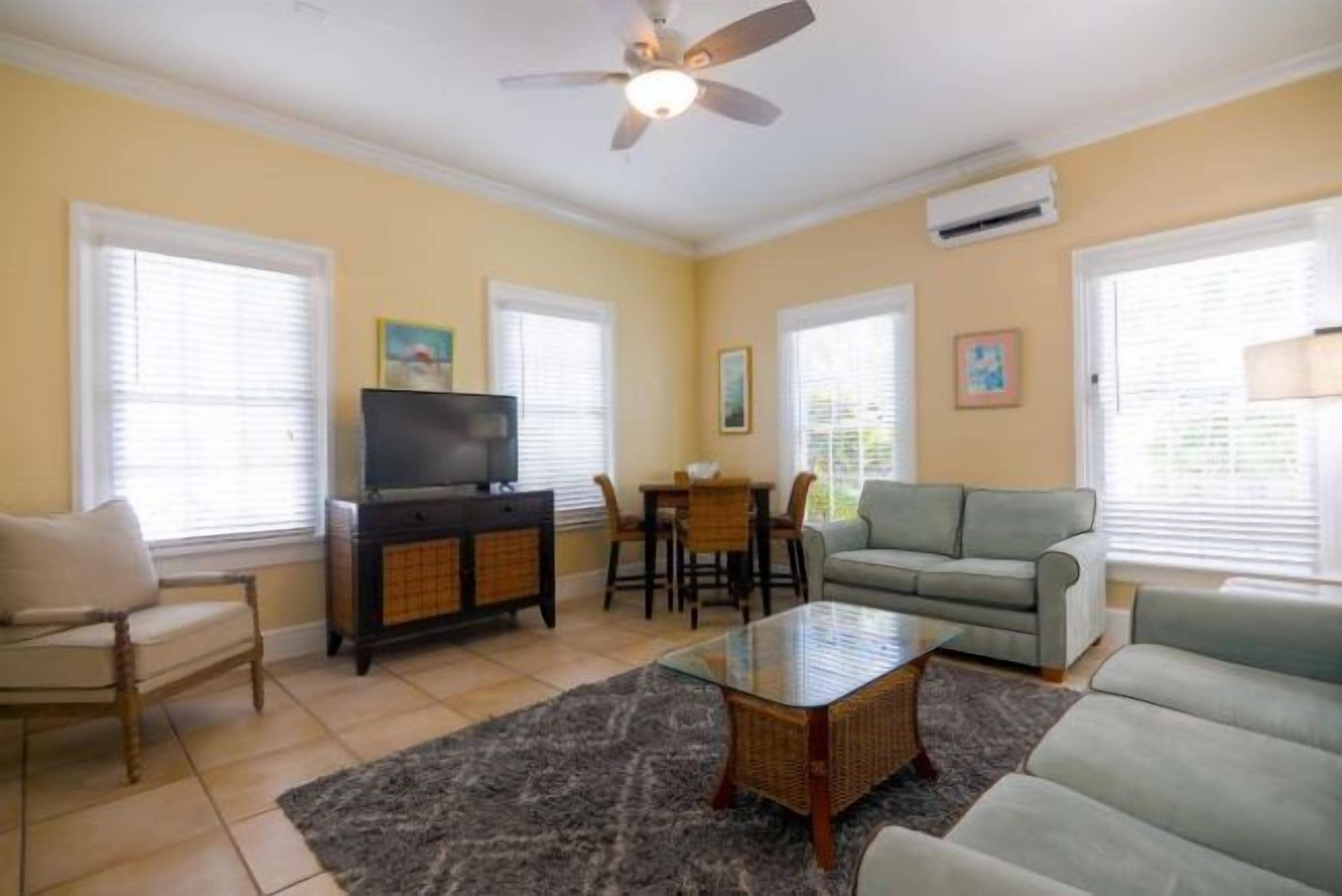 A living room with a television, sofa, coffee table, and dining area.